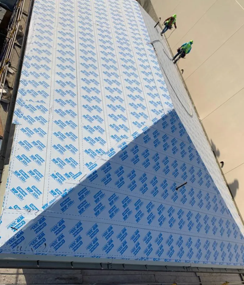 Professional roofers installing underlayment on a metal roof in Forest City